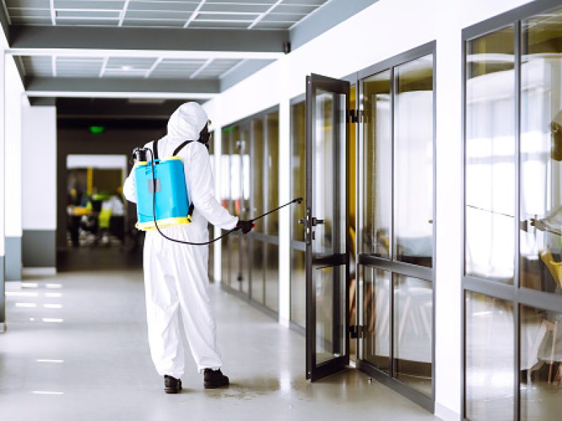Disinfection of office to prevent COVID-19, Man in protective hazmat suit with with spray chemicals to preventing the spread of coronavirus, pandemic in quarantine city. Cleaning concept.